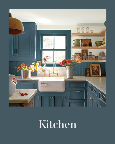 A kitchen with muted teal painted cabinets and trim, and a light blue-gray wall.