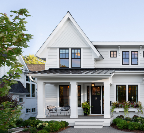 Exterior view of a modern white farmhouse style home with a front porch.