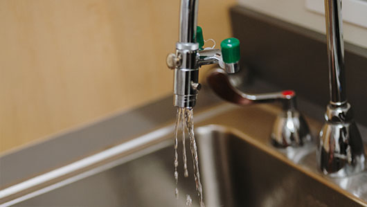 An open faucet with water running
