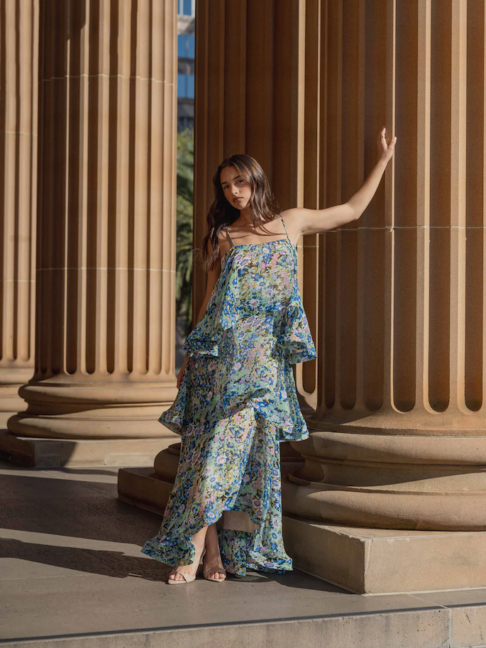 an image of a woman standing on a porch in a yellow dress