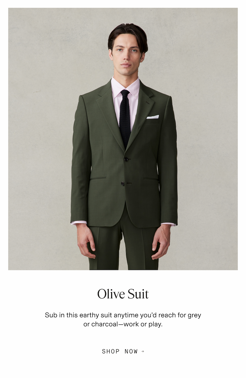 Model wearing an olive suit with pink shirt and black tie. Text reads: Olive Suit. Sub in this earthy suit anytime you’d reach for grey or charcoal—work or play. Button text: Shop Now.
