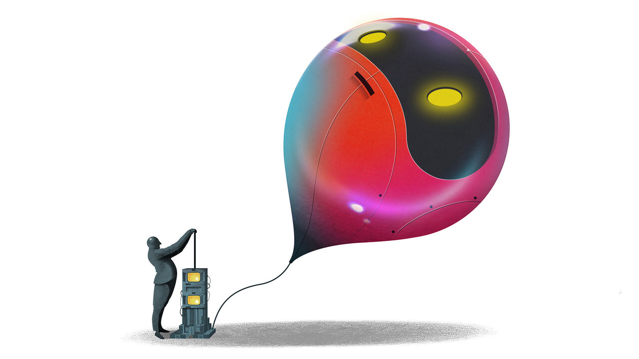 A man hand pumping a large balloon that resembles a robot face