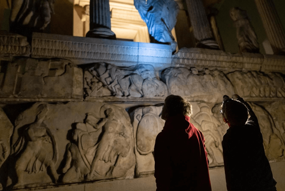 Children with torches and headlights in the Nereid Gallery at the British Museum.