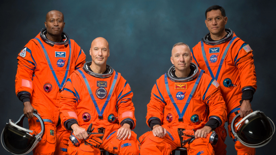 Four astronauts pose in uniform.