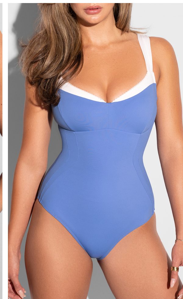 A woman wearing a blue one-piece swimsuit with white straps.