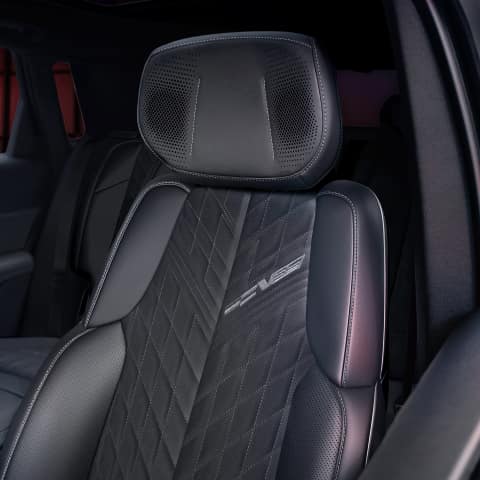 Interior of the 2026 LYRIQ-V highlighting the premium seating with exclusive V-Series badging and speakers in the headrest.