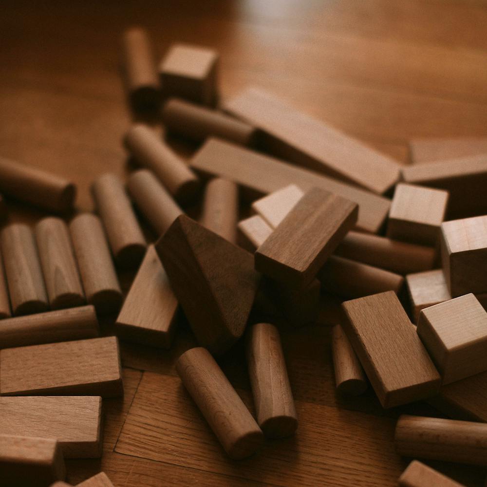 A pile of dark wood blocks of various shapes.