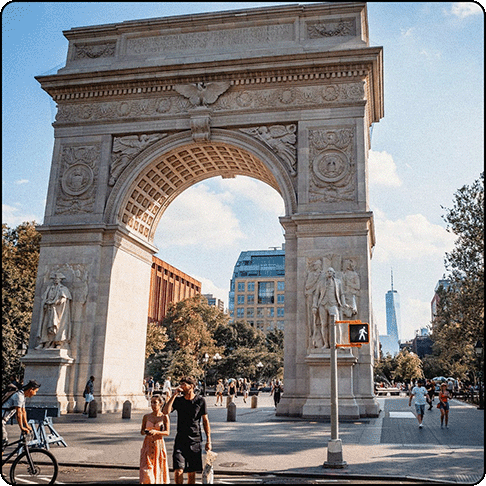Image Description: Large archway in Washington Square Park, NYC with people walking around the square.
