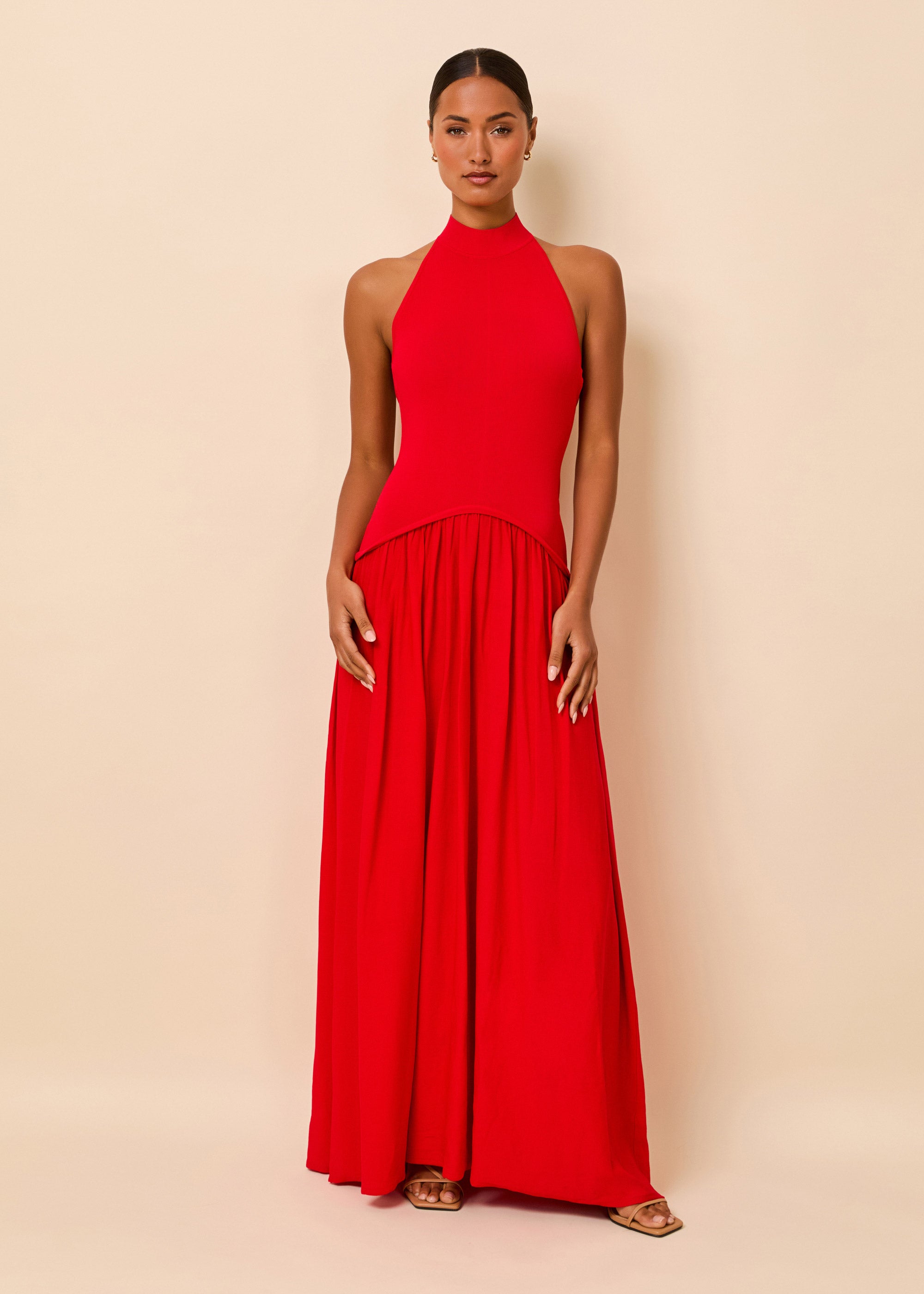 Woman in a bright red full length halter dress
