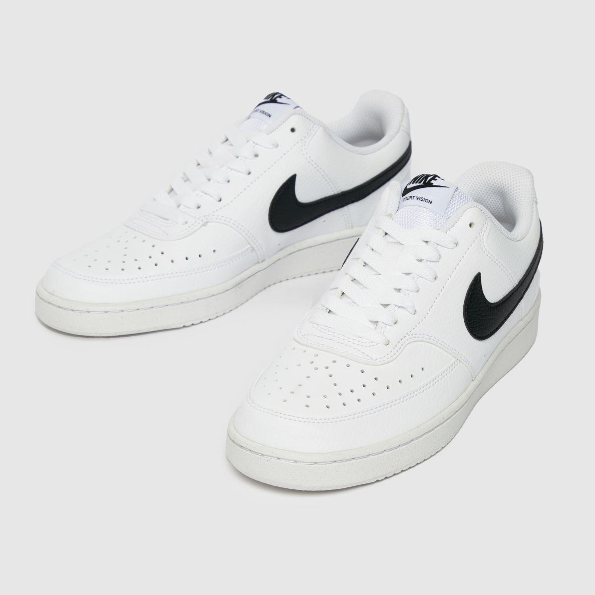 An image of a pair of white and black Nike trainers
