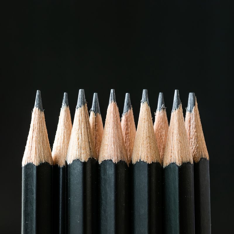 Closeup of pencil tips against a black background.
