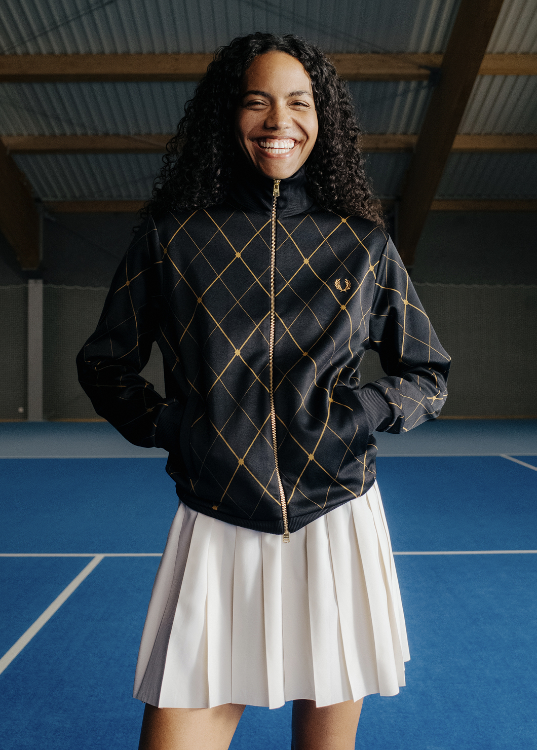 Female model wearing a Fred Perry Argyle Track Jacket in Black