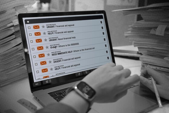 A photo illustration of a worker sitting at a messy desk looking at an email inbox on a laptop. Every email is an urgent request for financial aid assistance. 