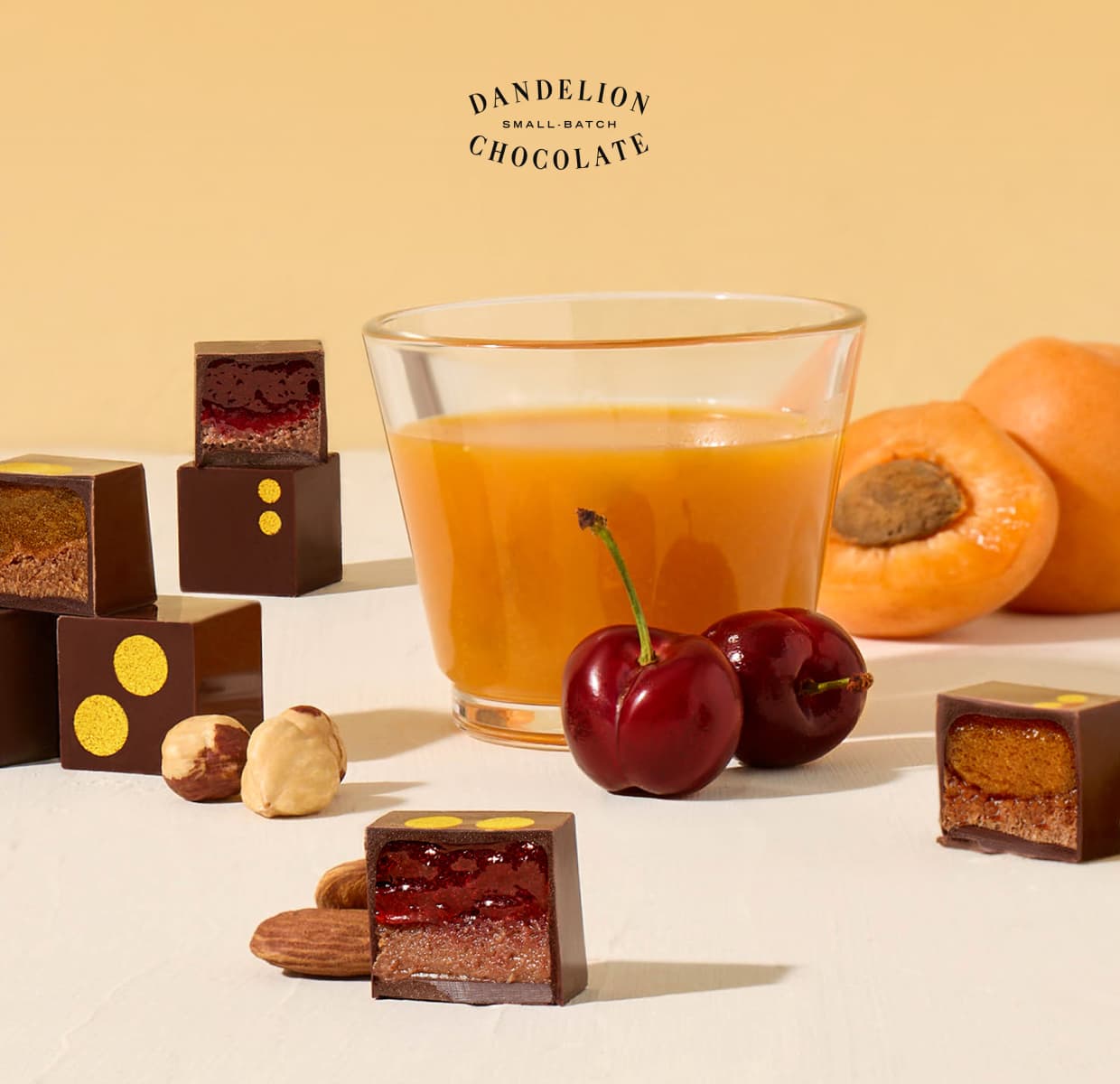 Bonbons from our Summer Harvest Collection next to stone fruit, passion fruit juice, and assorted nuts.