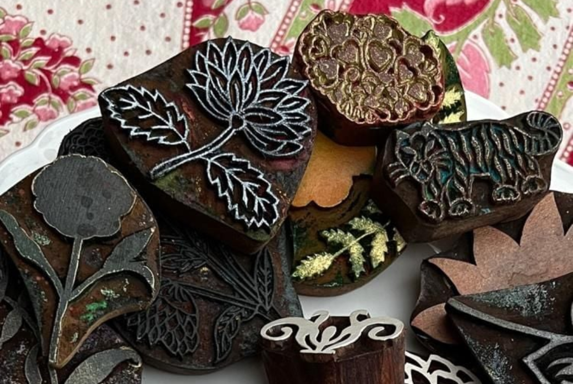 Collection of woodblock prints on floral fabric.