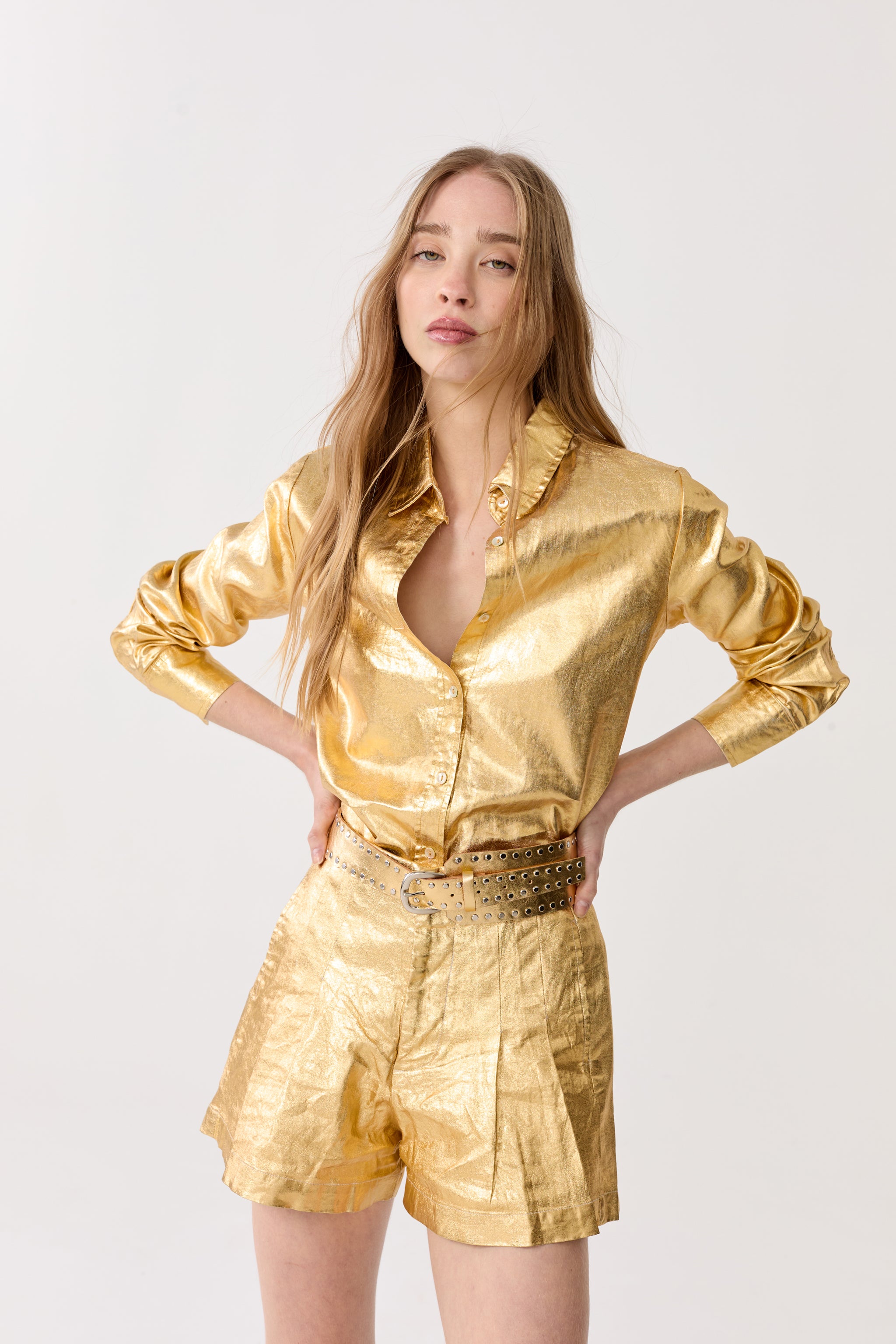 a model in a gold foil jacket and shorts