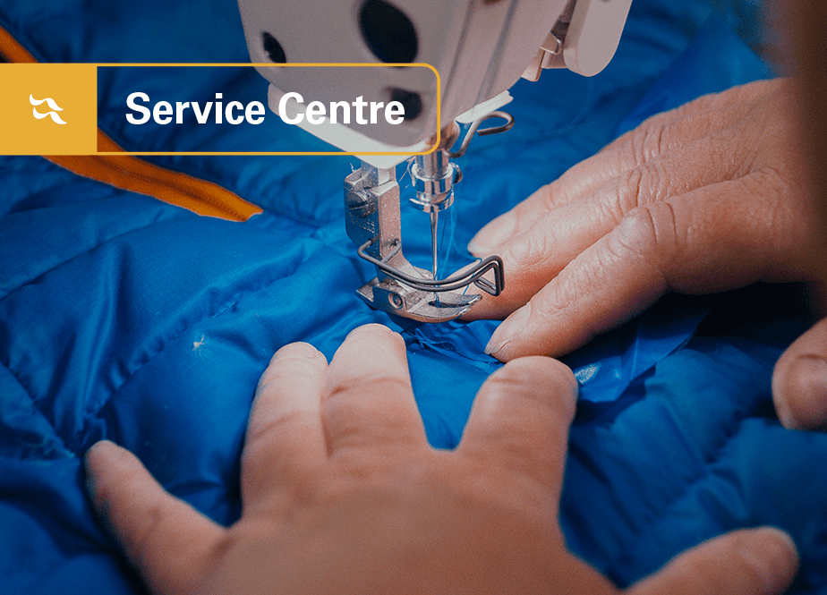 An insulated jacket being repaired with Service Centre logo inset.