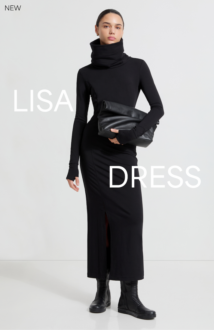 Mily in The Lisa Sweatshirt Dress poses with a large black clutch.