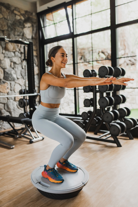 woman performing stretches on a balancing device