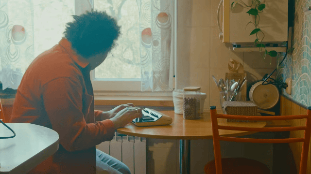 Dan bobs his head while playing Orchid at a kitchen table in Kazakhstan.