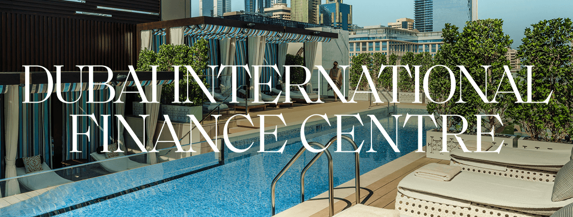 A woman walking past rooftop pool cabanas; the image includes the text 'Dubai International Finance Centre'.