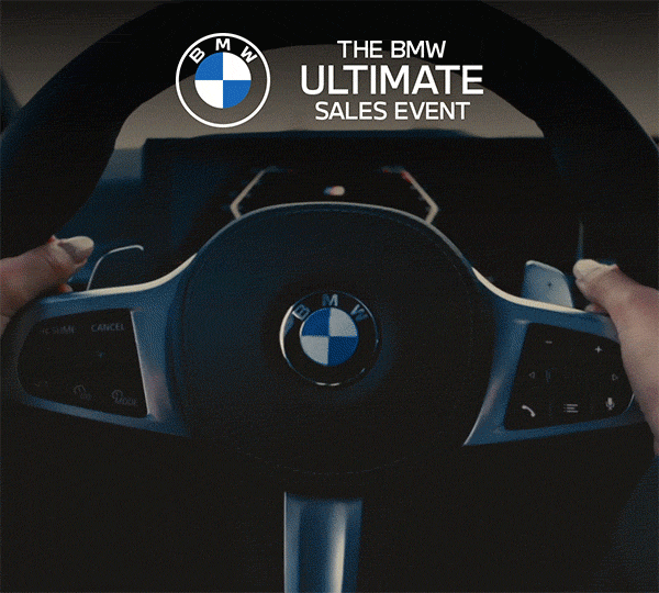 tthe Ultimate Sales Event text appears over BMW steering wheel.