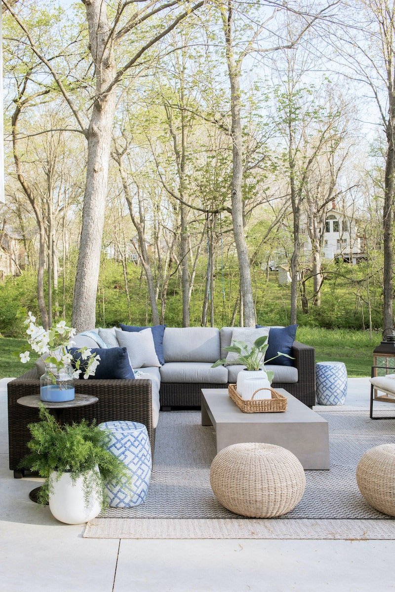 Modern outdoor living space featuring outdoor sectional, coffee table and poufs.