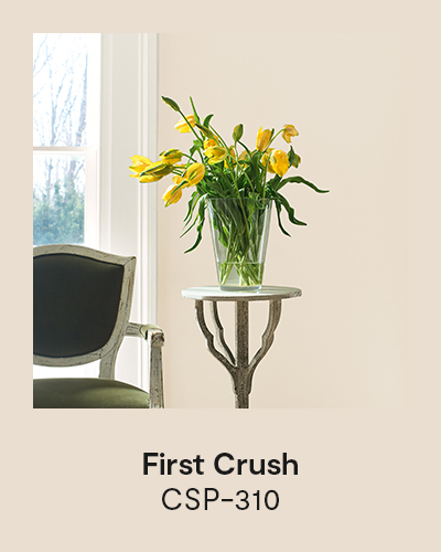 First Crush CSP-310 - An accent table topped with a vase of yellow tulips sits in front of a pale pink painted wall.
