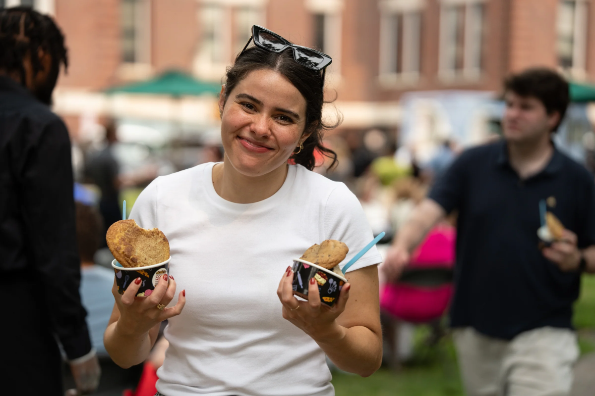 Woman in white tee holding two ice creams.
