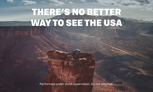 There’s no better way to see the USA. A lone Chevy pickup stands atop a towering mesa, framed by canyon walls and distant mountain peaks. Performed under stunt supervision. Do not attempt.