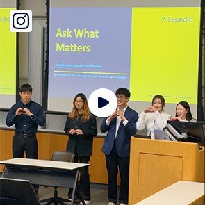 A group of students presents their project at the Hack-AI-thon, holding their hands in hearts.