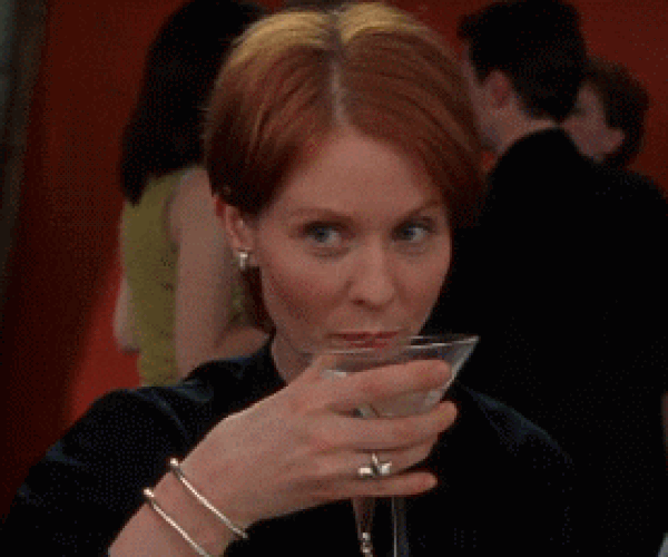 Miranda Hobbes from Sex and the City sips a martini while looking intently to the side.