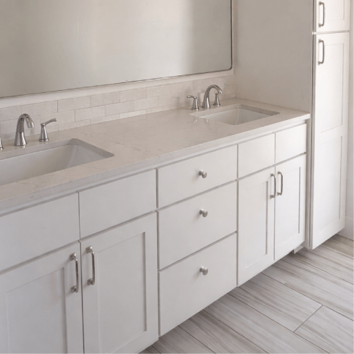 Modern bathroom with double sink and white cabinets.