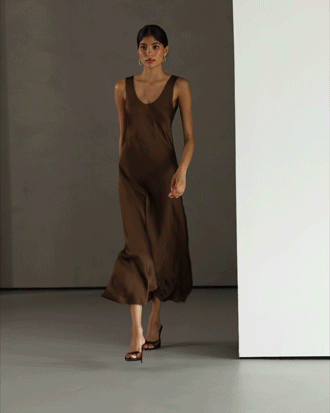 Model walking with the brown satin dress draping fluidly