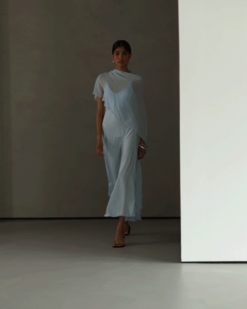 Model walking with the blue satin dress draping fluidly