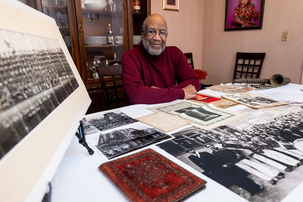Photo: Leland Clarke (Wheelock'75) at his home in Randolph, Mass., with some of the approximately 1,800 pieces of ephemera he’s collected that chronicle Roxbury’s history.