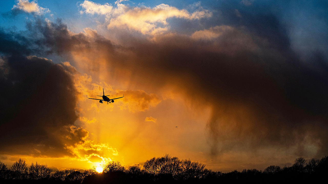 A Boeing 737 landing at sunset after a very heavy storm at Gatwick Airport, UK.