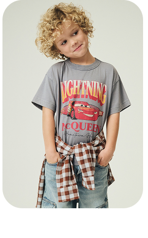 Child wearing grey Lightning McQueen graphic t-shirt with red plaid flannel shirt tied at waist