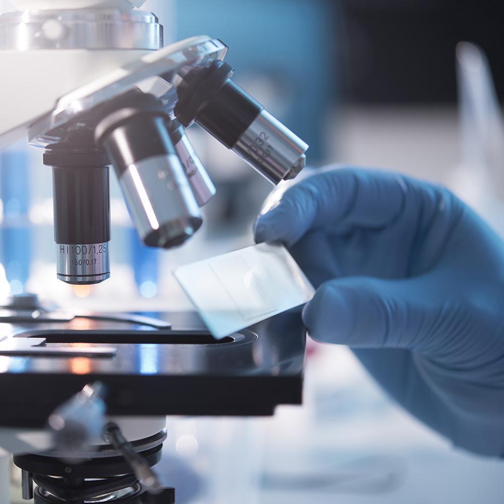 A scientist placing a slide under a microscope