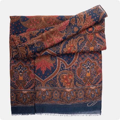 Product shot of a luxury wool scarf with a paisley pattern in burgundy and blue 