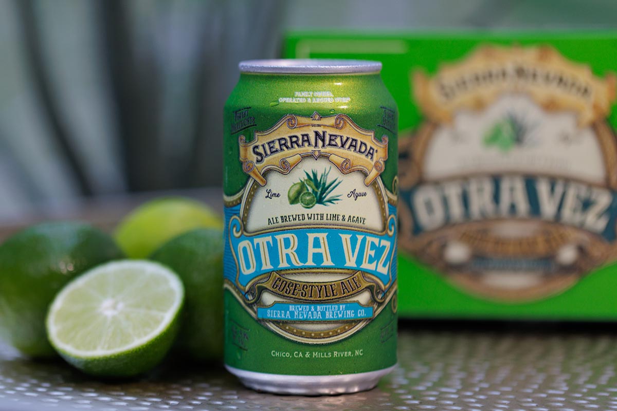 A can and six-pack of Otra Vez next to several limes