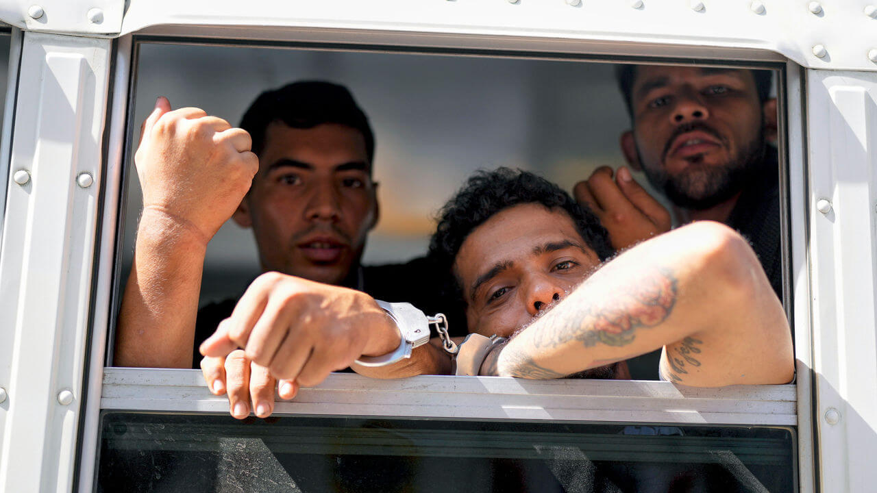 Colombian migrants look out the window of a Panamanian immigration bus