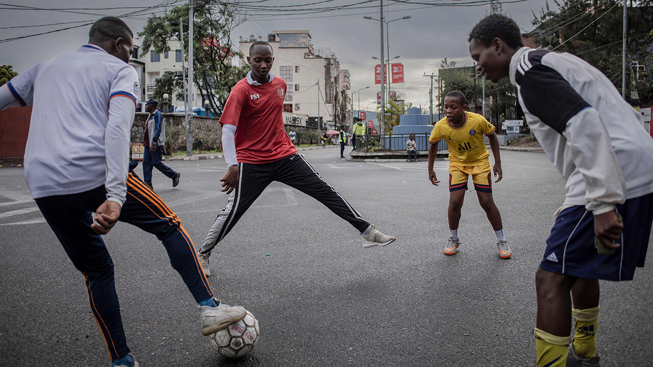 Young people play soccer in the street in Goma, DRC
