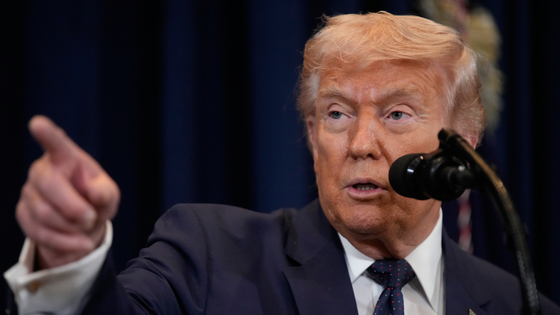 President Trump speaks into a microphone.