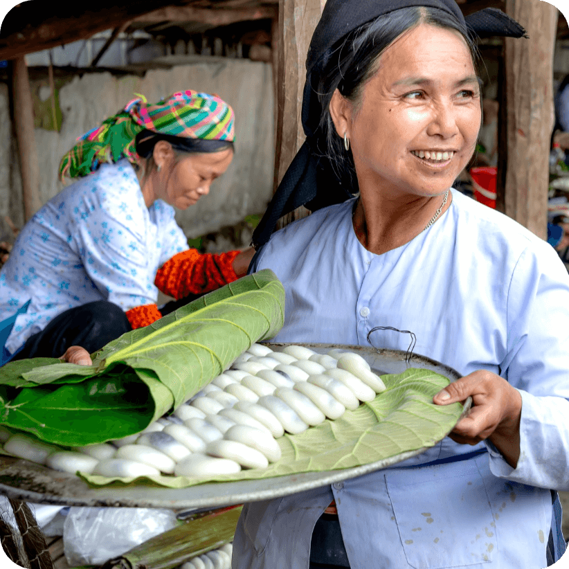 A woman holding fresh food under a leaf.