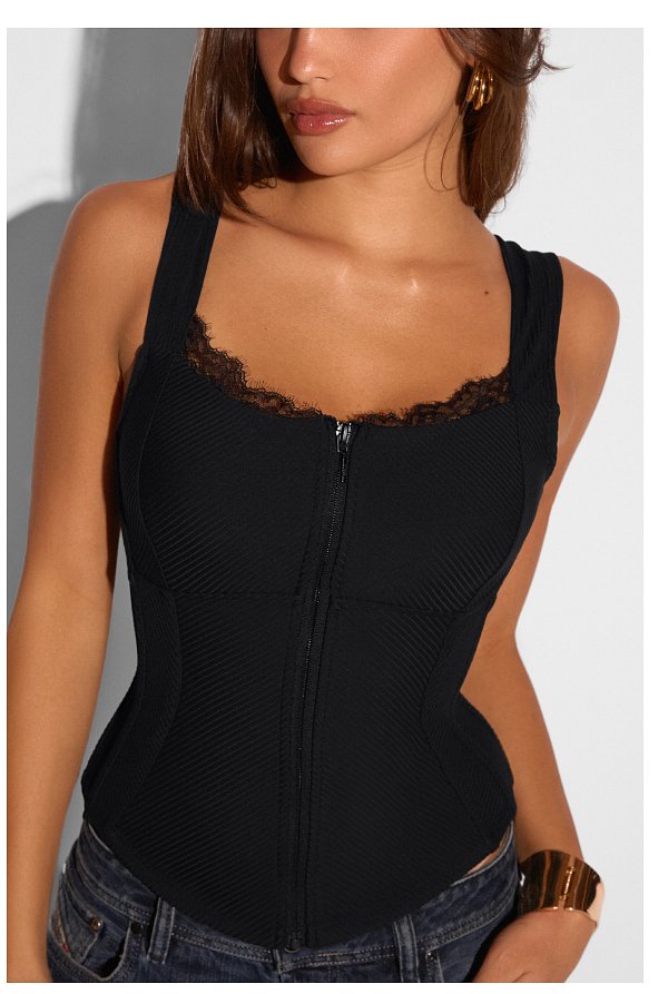 Black corset top with lace trim and zipper detail, worn by a woman.
