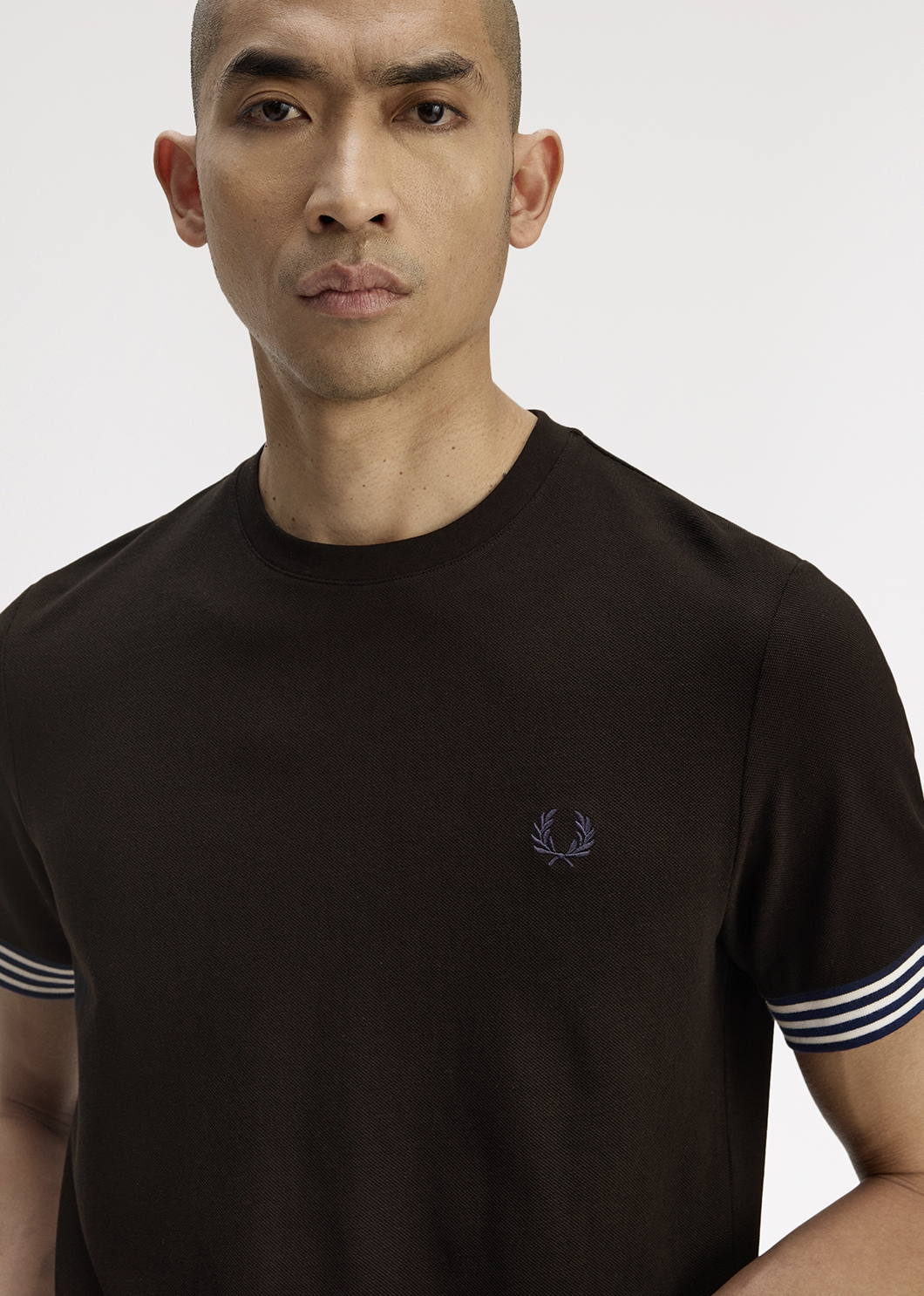 Male model wearing a Fred Perry Striped Cuff T-Shirt in Black