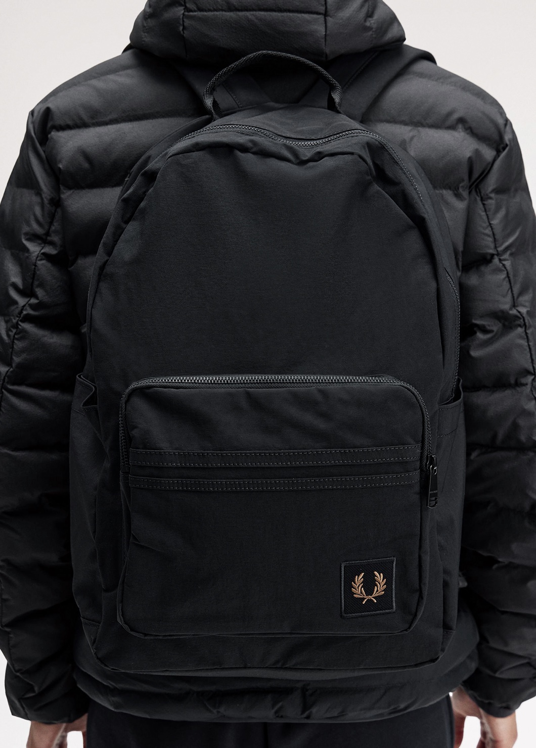 Close up of a Fred Perry Nylon Badge Backpack in Black