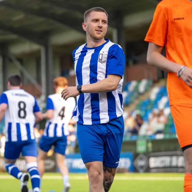 Soccer player wearing royal blue striped custom FORZA soccer uniform during a game.