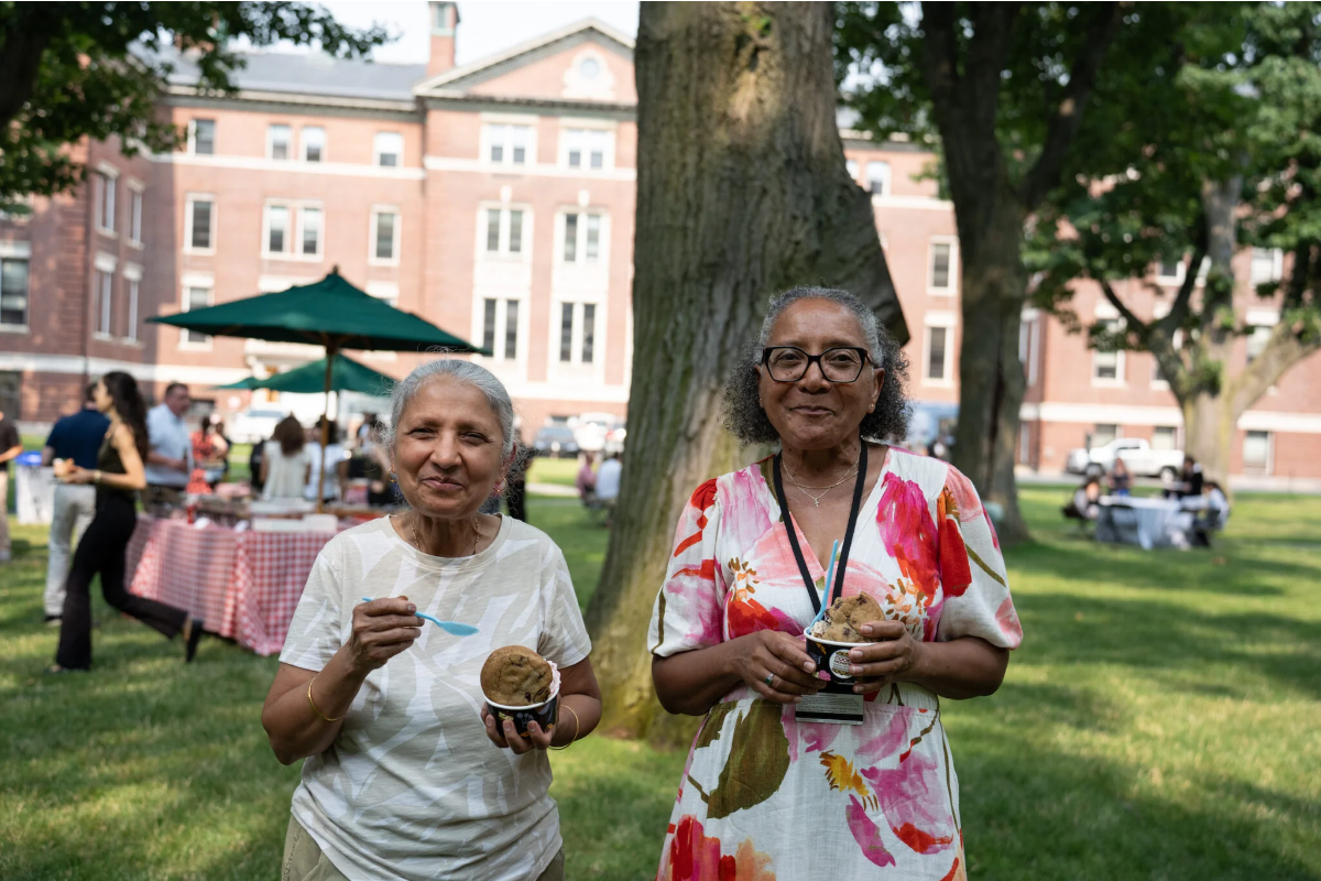 Two women smiling and holding ice cream. 